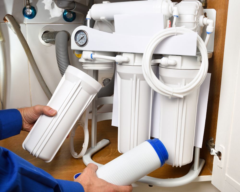 Technician replacing a filter cartridge in a water filtration system