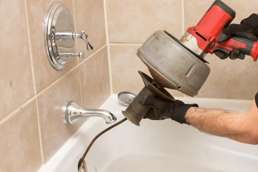 a plumber using a power drain auger